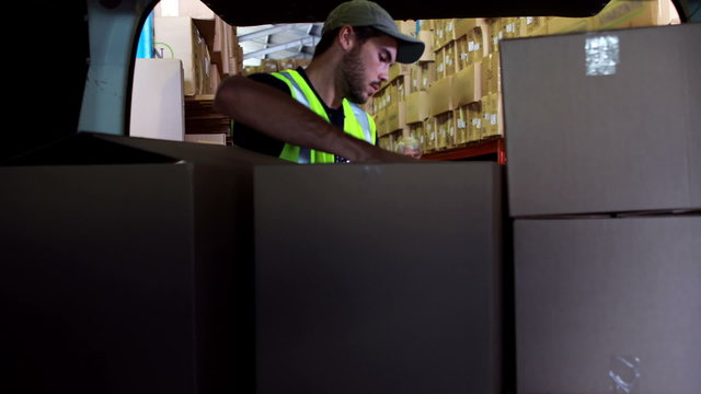 Delivery driver loading his van with boxes