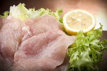slices of chicken with salad on wood