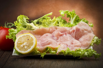 slices of chicken with salad on wood