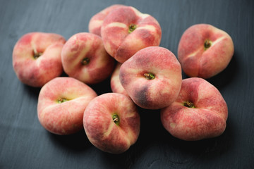 Flat peaches over black wooden background, high angle view