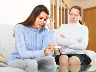 Sad  woman looking at pregnancy test