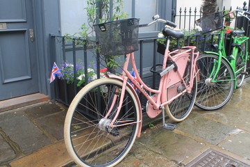 Fototapeta na wymiar Pink and green bicycles by the door with the british flag