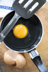 yolk in pan with eggshell