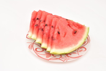 Cut pieces of watermelon on a plate on white background