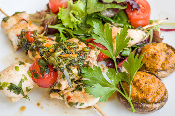 grilled meat and vegetables skewers on a slate plate