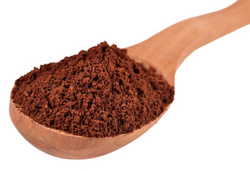 Ground coffee in a wooden spoon on a white