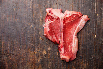 Raw fresh meat T-Bone Steak on dark wooden background
