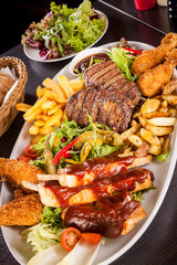 Platter of mixed meats, salad and French fries