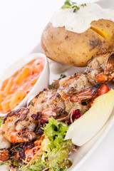 Grilled prawns with endive salad and jacket potato