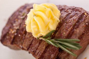 Grilled beef steak topped with butter and rosemary