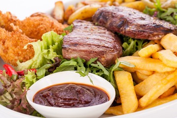 Platter of mixed meats, salad and French fries