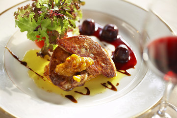 close up duck liver grilled and cherry sauce in white dish