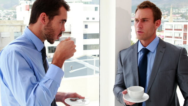 Businessmen chatting and drinking coffee