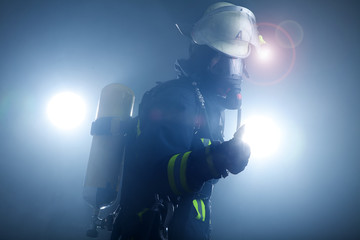 Feuerwehrfrau in Anzug und Atemschutzmaske mit Sauerstoffflasche Porträt