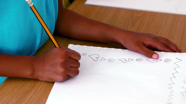 Little boy doodling in white notepad