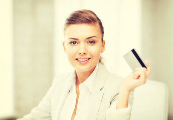 smiling businesswoman showing credit card