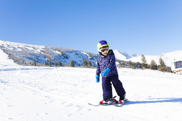 Fototapeta na wymiar Kid in ski mask skiing on snow downhill