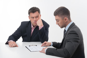 Two business people in elegant suits, chief and employee, holdin