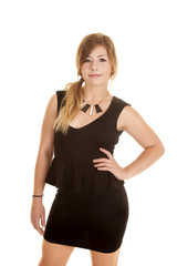 woman black dress with hand on hip small smile