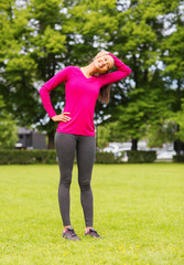 smiling black woman stretching leg outdoors