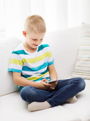 smiling little boy with smartphone at home