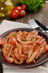 Pasta with tomato sauce on plate on table close-up