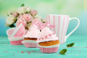 Tasty cup cakes with cream on blue wooden table