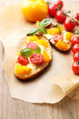 Tasty bruschetta with tomatoes, on old wooden table