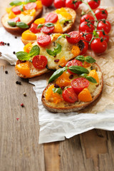 Tasty bruschetta with tomatoes, on old wooden table
