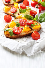 Tasty bruschetta with tomatoes, on table