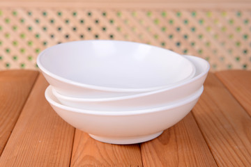 Set of white dishes on table on light background