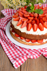 Delicious biscuit cake with strawberries on table close-up