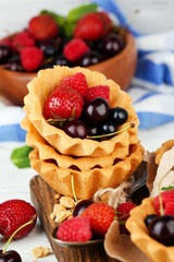 Tasty tartlets with berries on wooden table