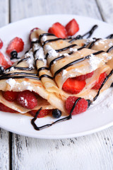 Delicious pancakes with berries on table close-up