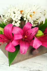 Beautiful flowers in crate on wooden background