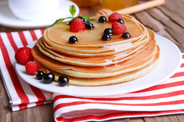 Sweet pancakes with berries on table close-up