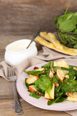 Green salad with apples, walnuts and cheese on wooden