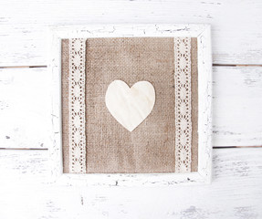 Wooden frame with paper heart isolated on white