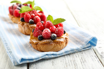 Sweet cakes with berries on table close-up
