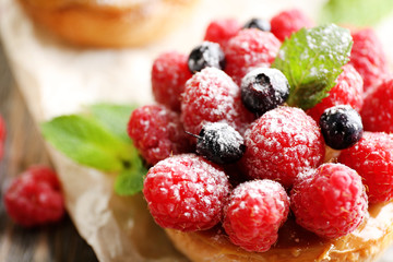 Sweet cakes with berries on table close-up