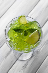 Green jelly with mint leaves in glass on wooden background