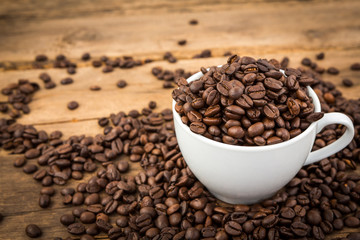 Coffee cup and coffee beans on a wooden table