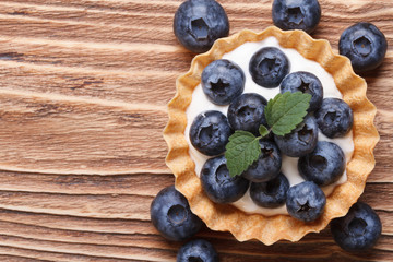 Tartlet with fresh blueberries on a wooden horizontal top view