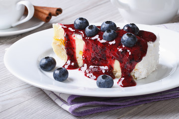 Cake with blueberry, berry sauce on plate and coffee