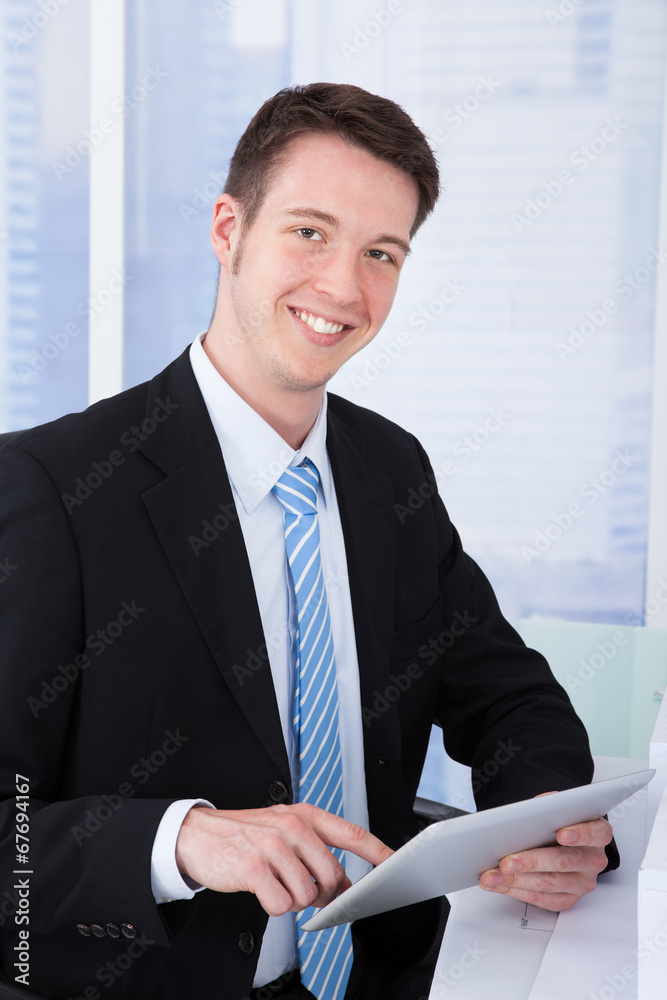 Poster confident businessman using tablet computer at desk
