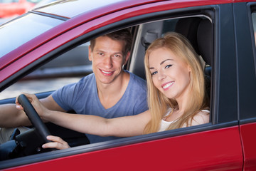 Happy Woman With Man Sitting In New Car