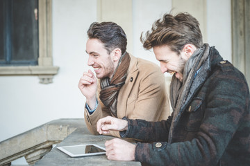 two young handsome businessmen using tablet