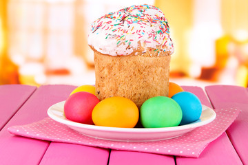 Sweet Easter cakes with colorful eggs on table in room