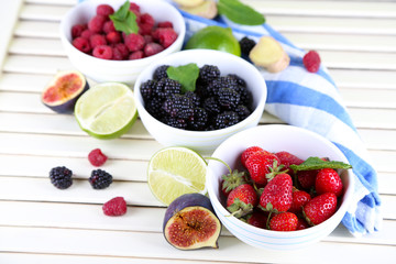 Assortment of juicy fruits and berries on wooden background