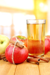 Ripe apples with with cinnamon sticks and glass of  apple drink